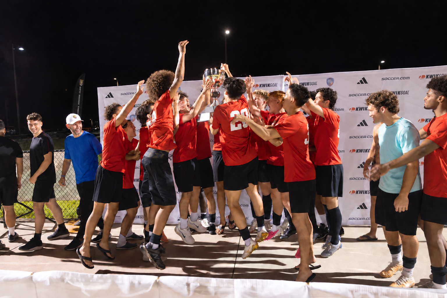 Soccer players celebrating together with a championship trophy